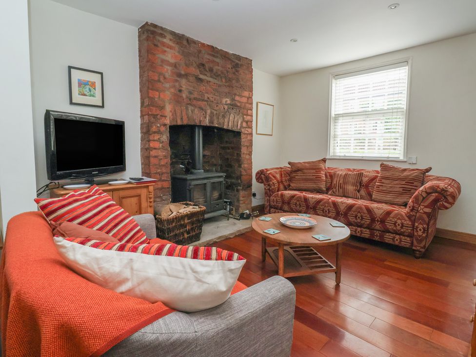 A living room with a fireplace and two sofas at Pear Tree Cottage in Great Ouseburn