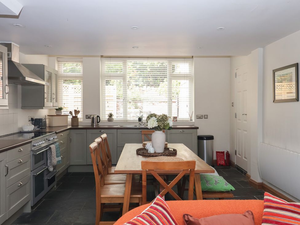 A kitchen with a table and chairs at Pear Tree Cottage in Great Ouseburn