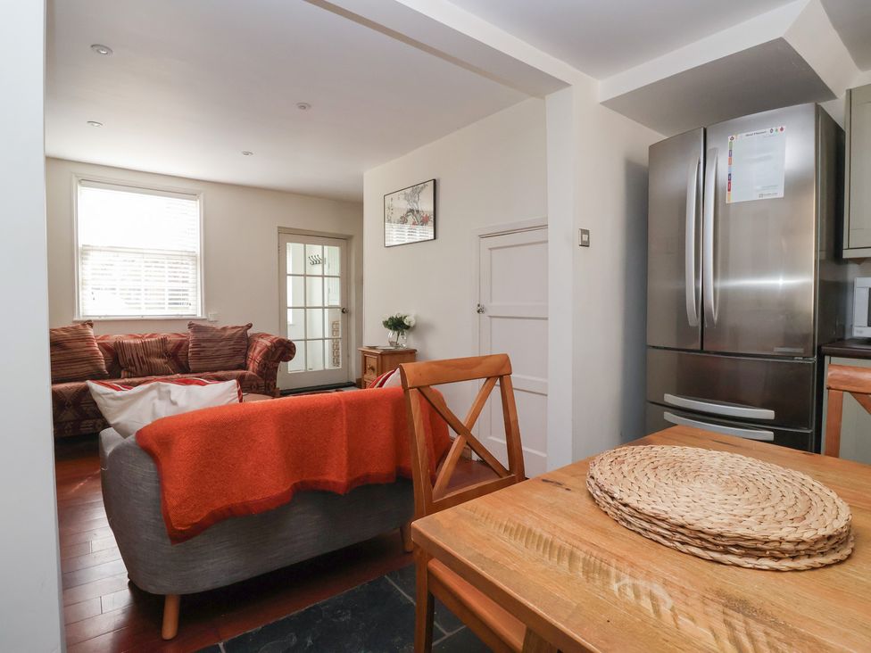 A living room with a dining table, sofa and refrigerator at Pear Tree Cottage in Great Ouseburn