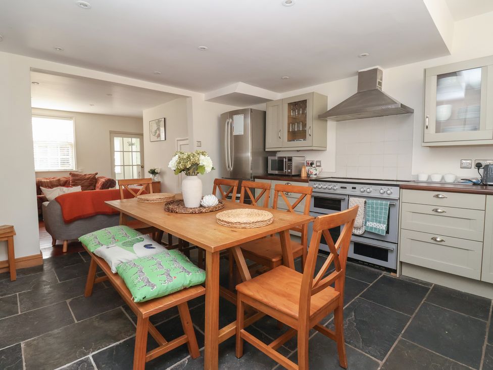 A kitchen with a dining table and appliances at Pear Tree Cottage in Great Ouseburn