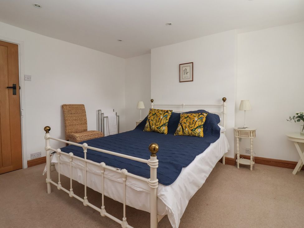 A bedroom with a bed and a bedside table at Pear Tree Cottage in Great Ouseburn