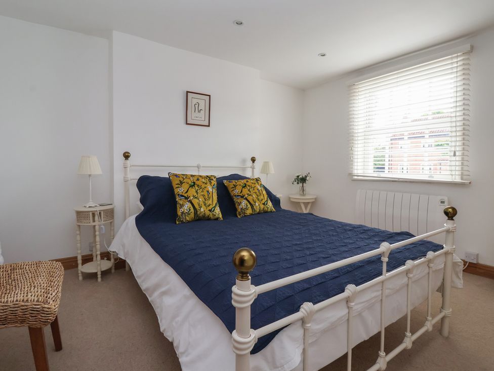 A bedroom with a bed and side tables at Pear Tree Cottage in Great Ouseburn
