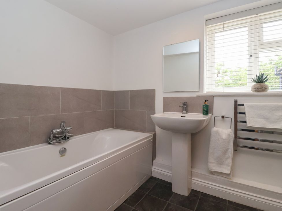 A bathroom with a bathtub and sink at Pear Tree Cottage in Great Ouseburn