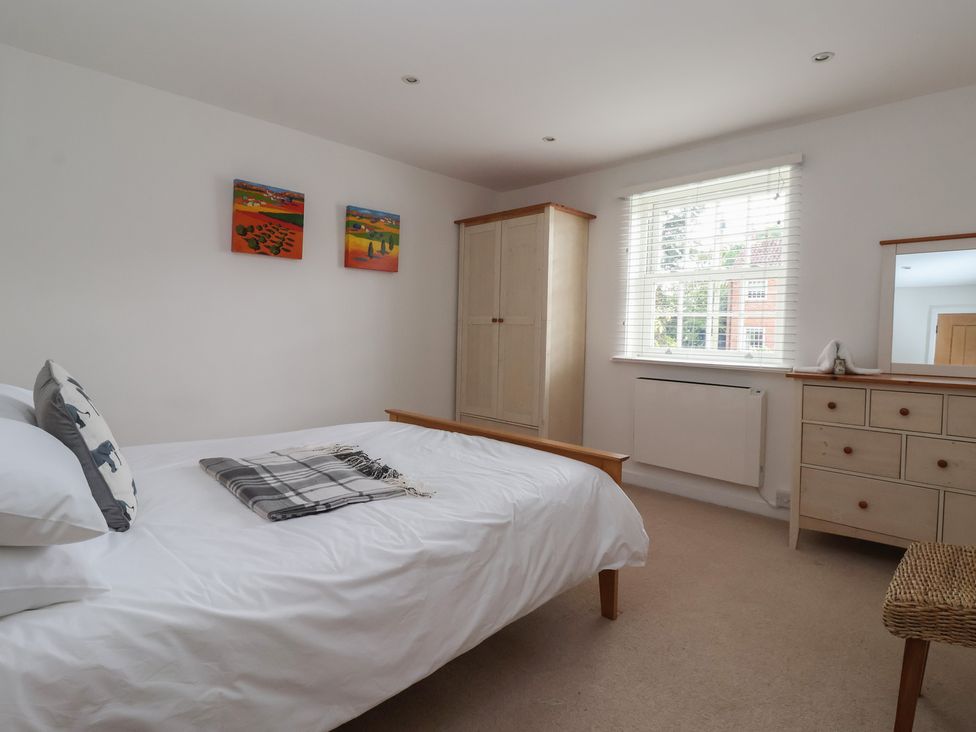 A bedroom with a bed and wardrobe at Pear Tree Cottage in Great Ouseburn