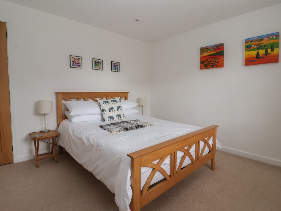 A bedroom with a bed and wall art at Pear Tree Cottage in Great Ouseburn