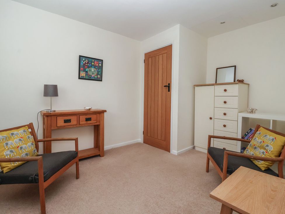 A sitting room with a side table and chairs at Pear Tree Cottage in Great Ouseburn
