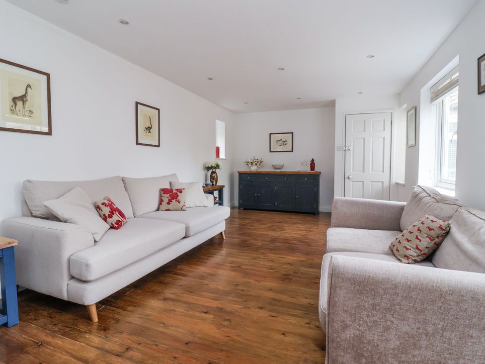 A living room with two sofas and a cabinet at Pear Tree Cottage Great Ouseburn