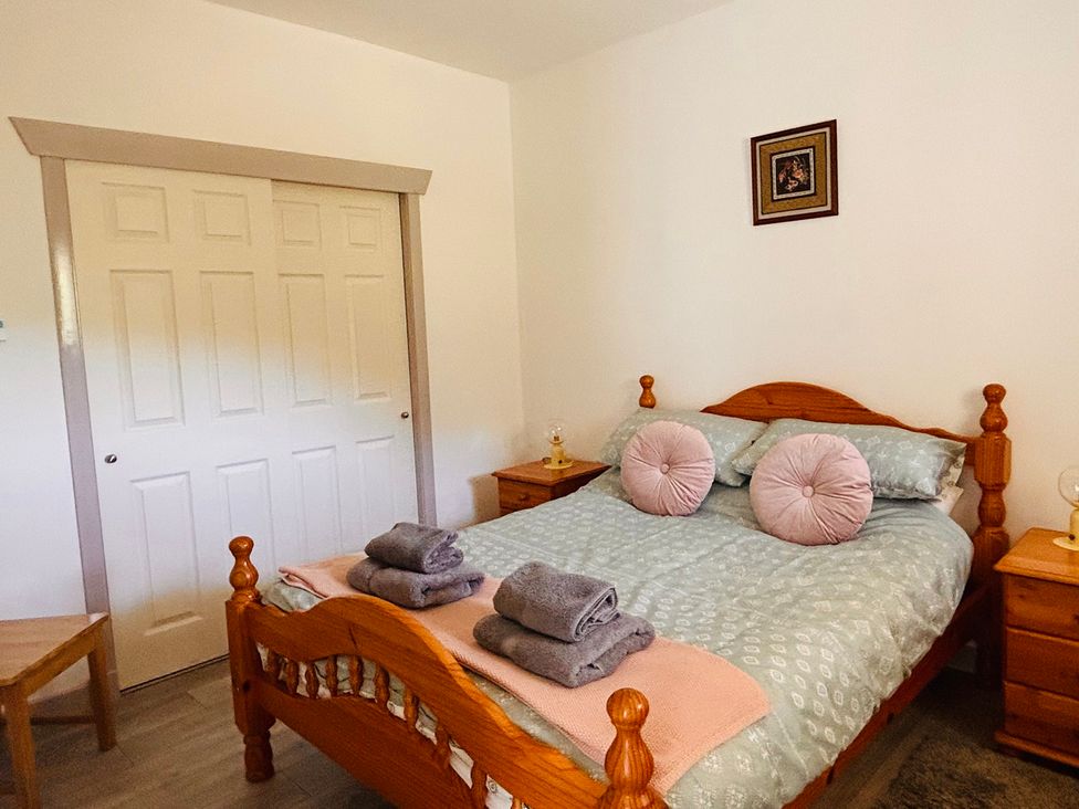 A bedroom with a bed and bedside tables at Bathach Mor in Balvicar, Isle Of Seil
