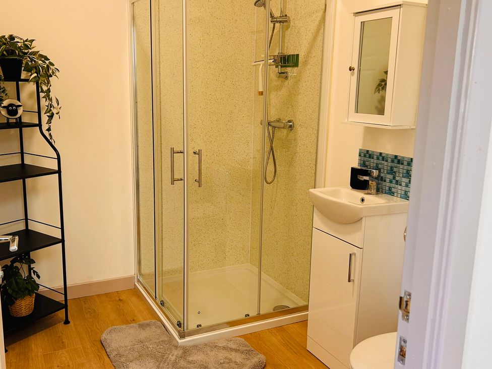 A bathroom with a shower, sink, and shelf at Bathach Mor, Balvicar, Isle Of Seil