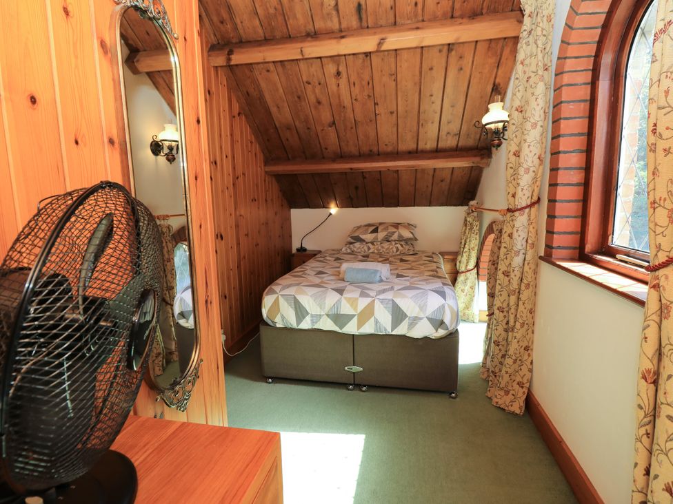 A bedroom with a bed and mirror at The Chapel in Northwood, Isle Of Wight