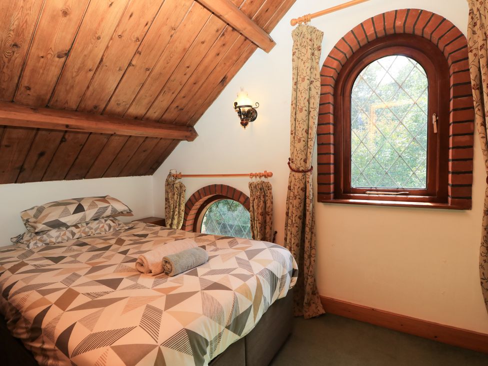 A bedroom with a bed and windows at The Chapel in Northwood, Isle Of Wight