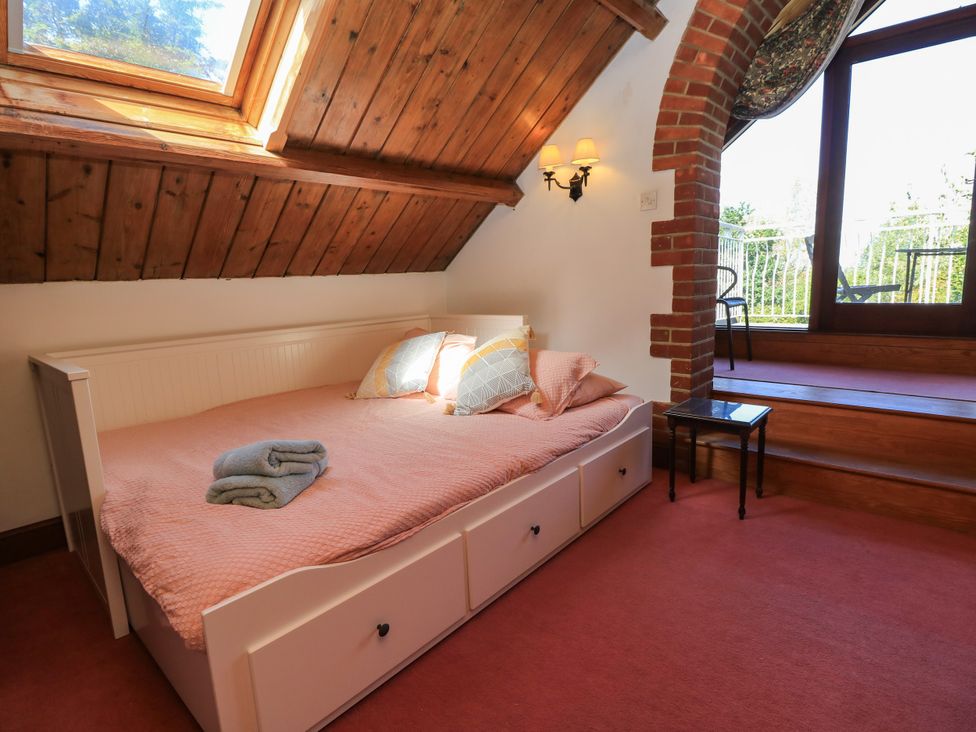 A bedroom with a bed and a coffee table at The Chapel in Northwood, Isle Of Wight