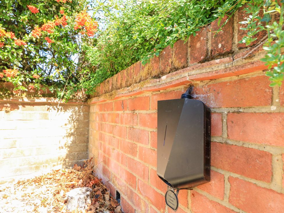 A hose connection attached to a brick wall with plants at The Chapel in Northwood, Isle Of Wight