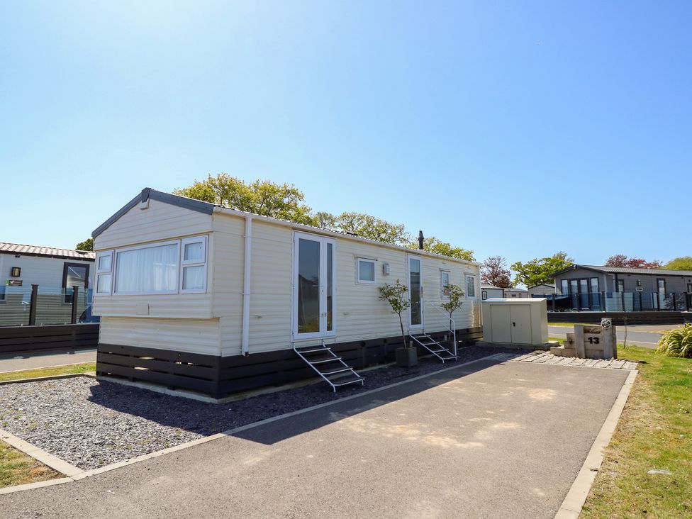 A mobile home with steps and planters at MillRythe Holiday Park (Dunlin Walk 13) Hayling Island