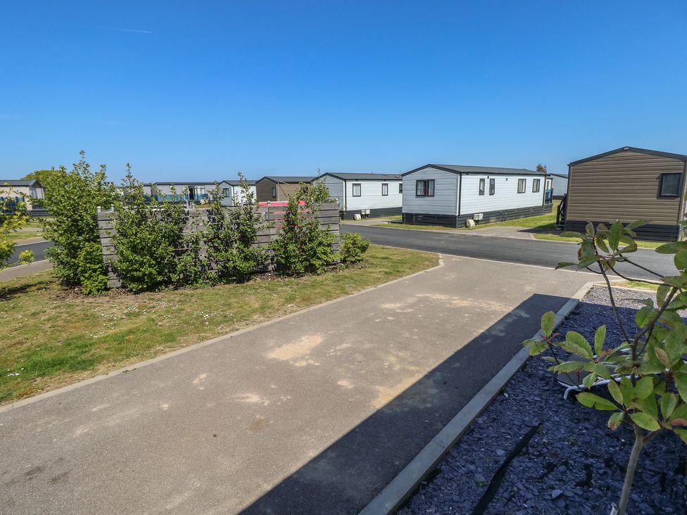An outdoor area with caravans and a path at MillRythe Holiday Park (Dunlin Walk 13) Hayling Island