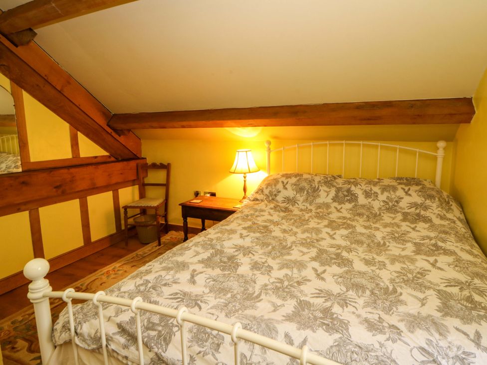 A bedroom with a bed and lamp at Maggie's Barn in Brecon