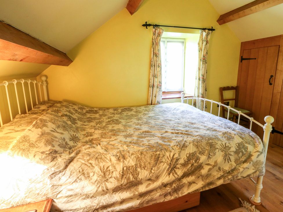 A bedroom with a bed and a window at Maggie's Barn in Brecon