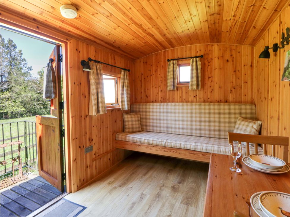 A seating area with couch and table at Bill’s Shepherds Hut near Talgarth