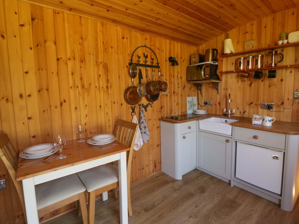 A kitchen with a table and chairs at Bill’s Shepherds Hut near Talgarth