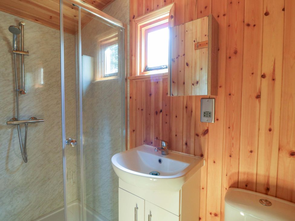 A bathroom featuring a shower, sink, and toilet at Bill’s Shepherds Hut near Talgarth