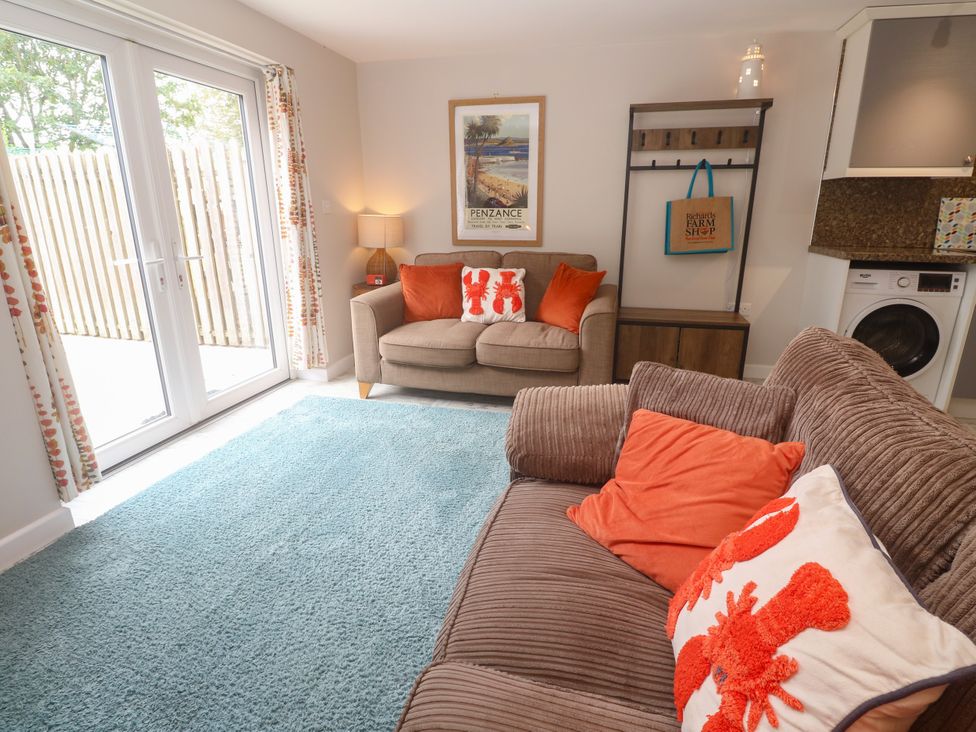 A living room with a sofa and washing machine at The Packing House in Rosudgeon