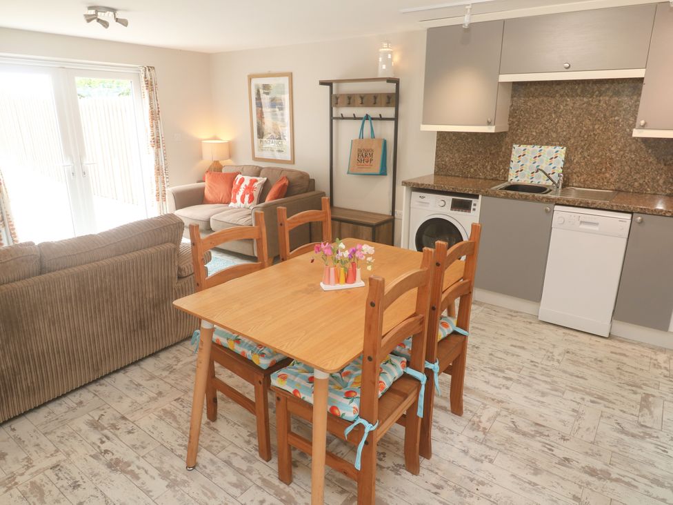 A kitchen with dining table and appliances at The Packing House in Rosudgeon