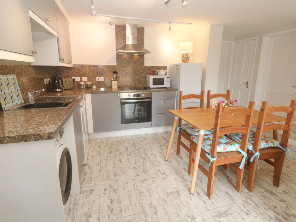 A kitchen with a dining table and appliances at The Packing House in Rosudgeon