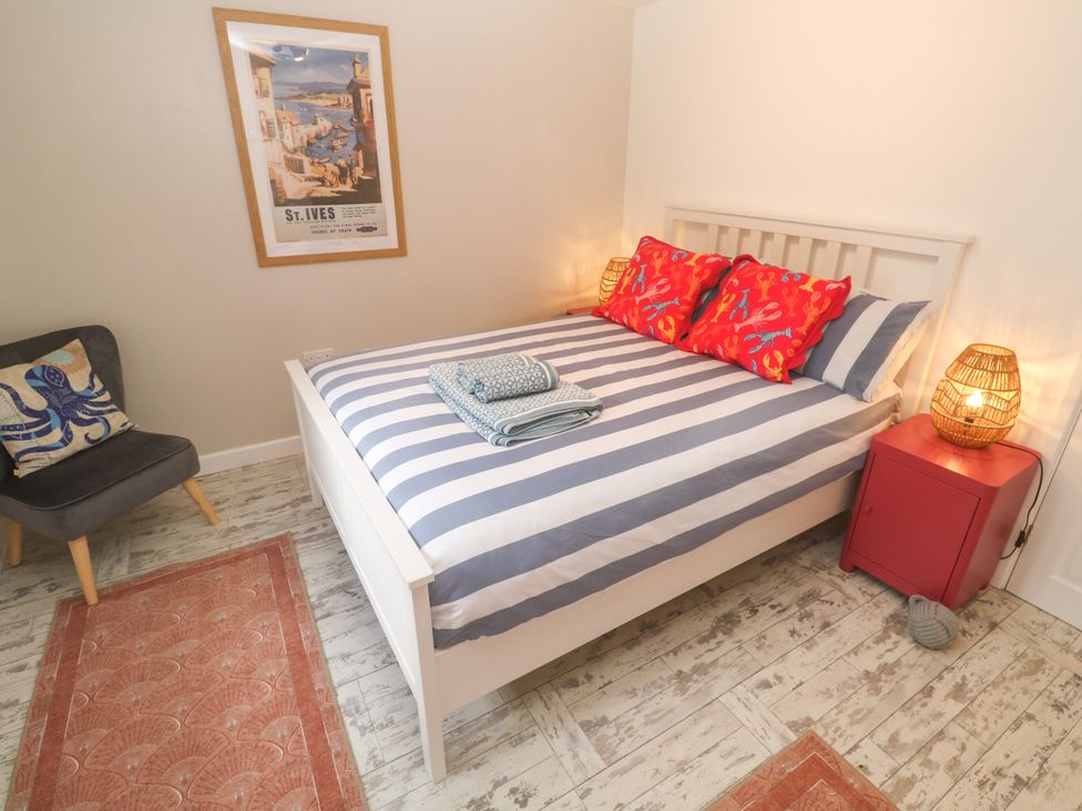 A bedroom with a bed and wall art at The Packing House in Rosudgeon