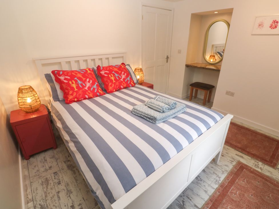A bedroom with a bed and nightstand at The Packing House in Rosudgeon
