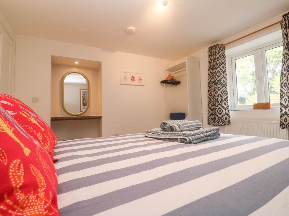 A bedroom with a bed and a wardrobe at The Packing House in Rosudgeon