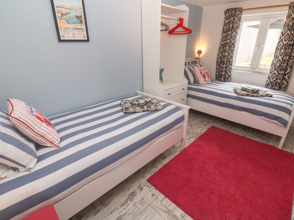 A bedroom with two single beds and a dresser at The Packing House in Rosudgeon