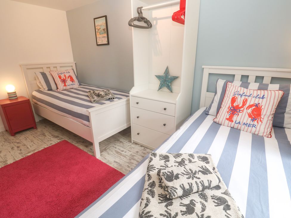 A bedroom with two beds and a drawer unit at The Packing House in Rosudgeon