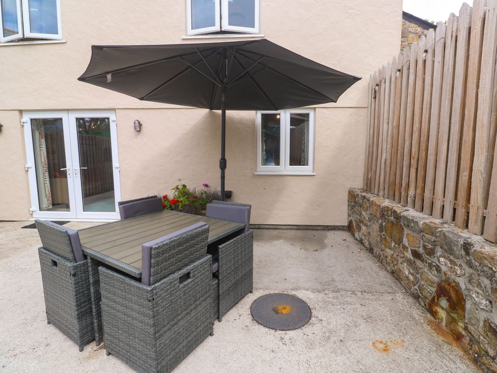 An outdoor dining area with a table and chairs at The Packing House in Rosudgeon