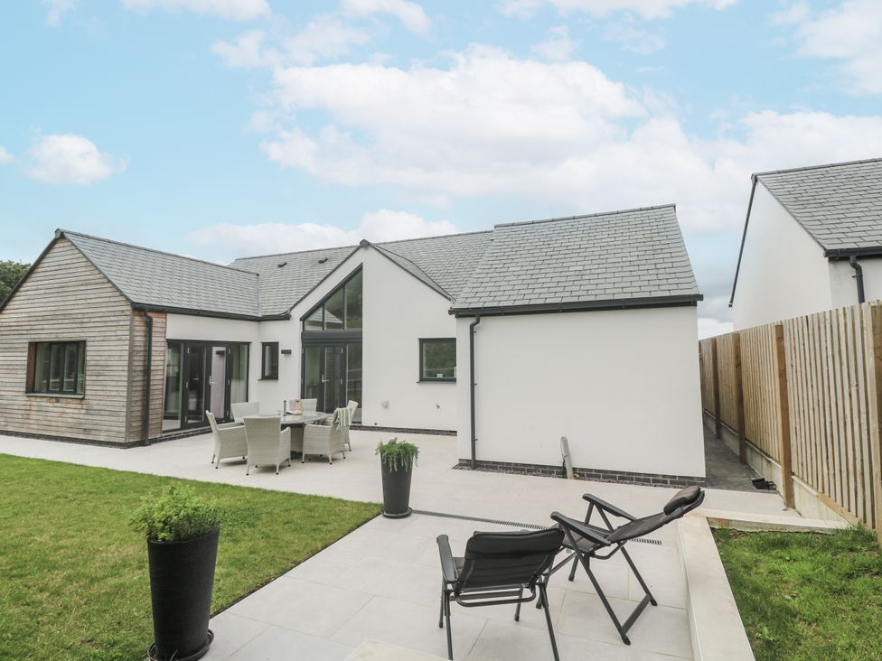 An outdoor area with a house, dining set and planters at Kerrek Lodge Mylor Bridge