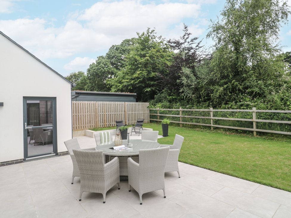 An outdoor seating area with a table and chairs at Kerrek Lodge in Mylor Bridge