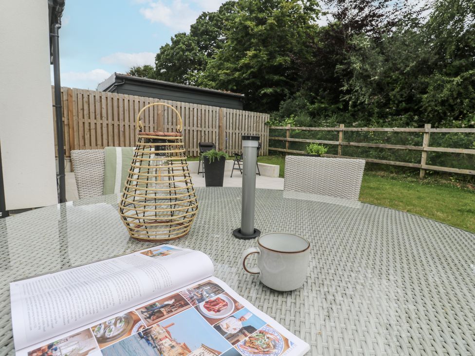 An outdoor space with a table and chairs at Kerrek Lodge in Mylor Bridge