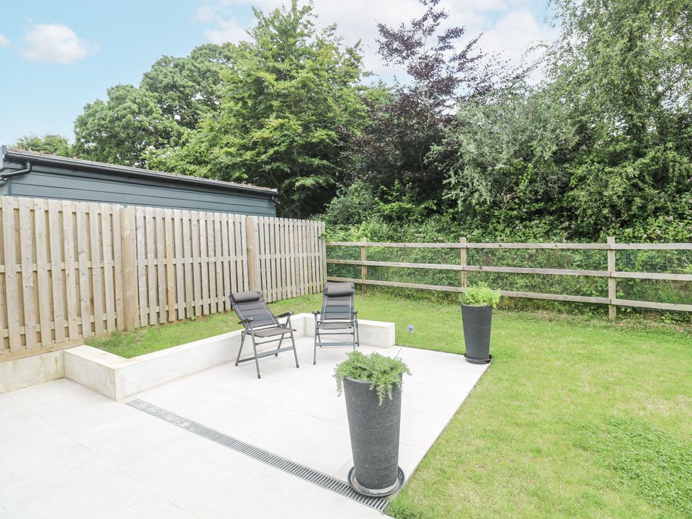 A garden area with chairs and planters at Kerrek Lodge in Mylor Bridge