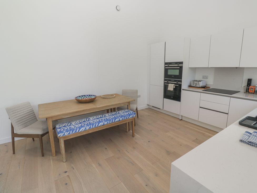 A kitchen with a wooden table and chairs at Kerrek Lodge Mylor Bridge