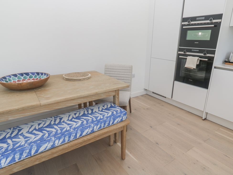 A kitchen with a table and chairs at Kerrek Lodge in Mylor Bridge