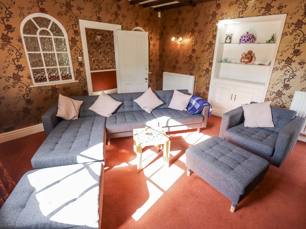 A living room with grey furniture and shelves at Holme Farm in Ruskington