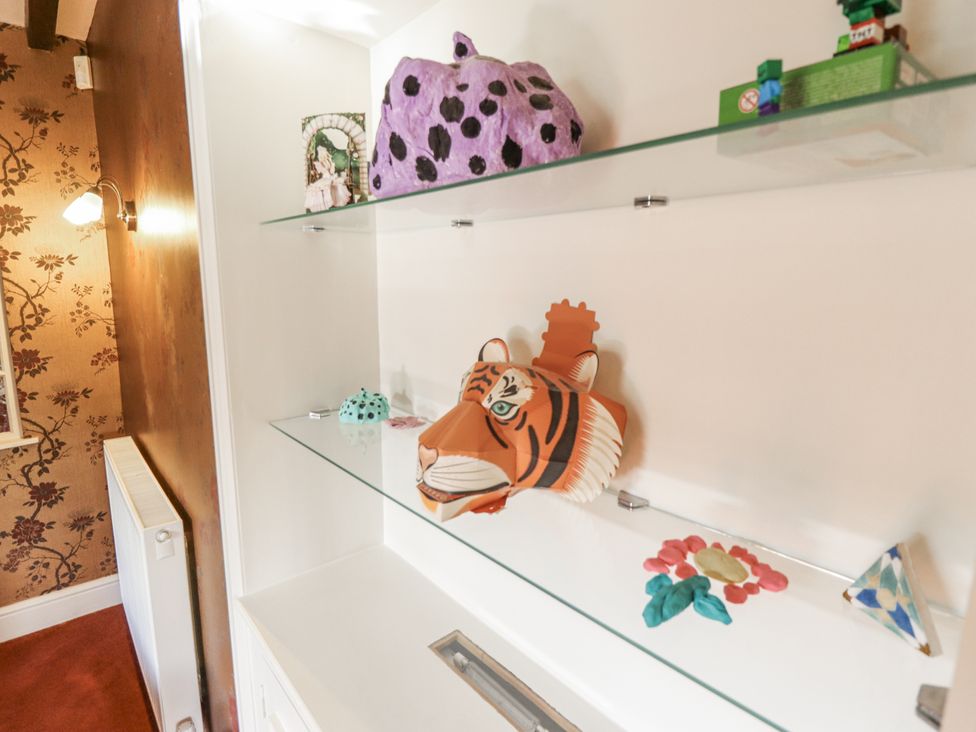 A shelf with decorative items including a tiger mask at Holme Farm in Ruskington