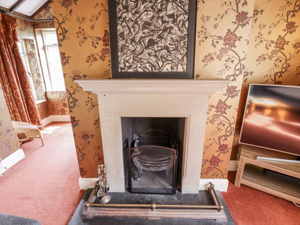 A living room with a fireplace and a television at Holme Farm in Ruskington