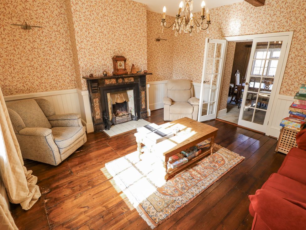 A living room with a sofa, armchair, and coffee table at Holme Farm in Ruskington