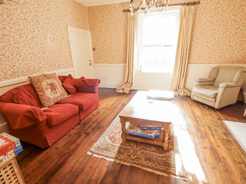 A living room with a red sofa and armchair at Holme Farm in Ruskington