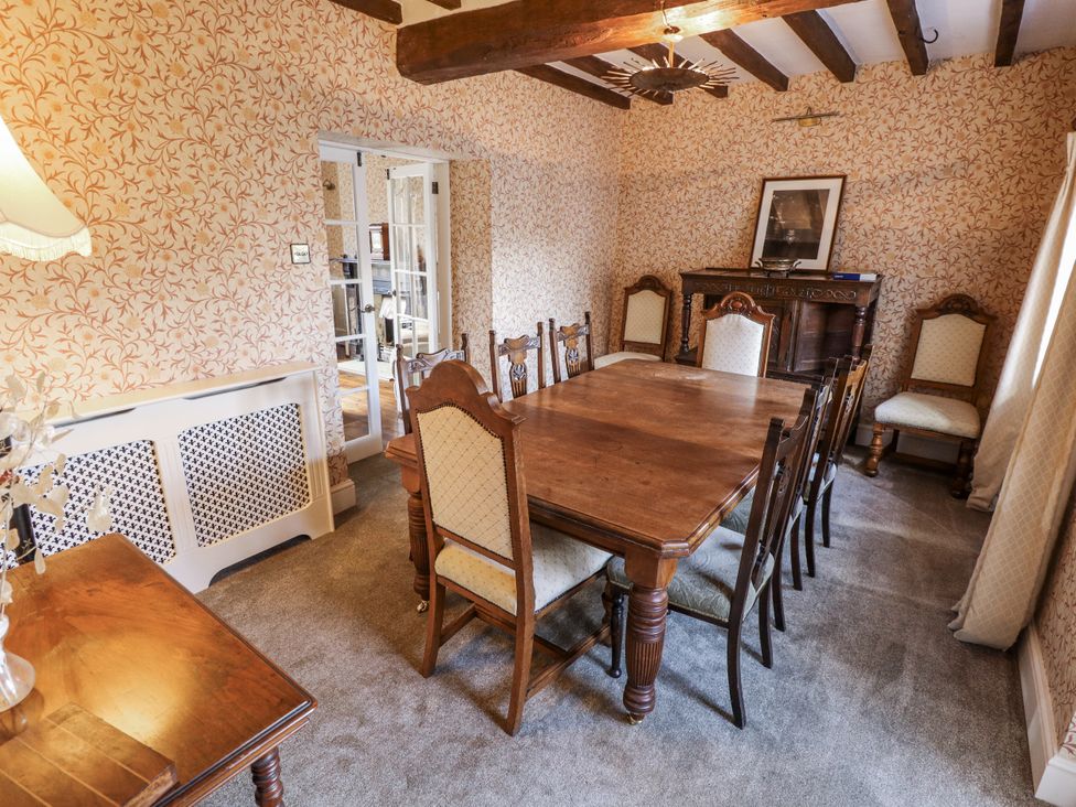 A dining room with a wooden table and chairs at Holme Farm in Ruskington