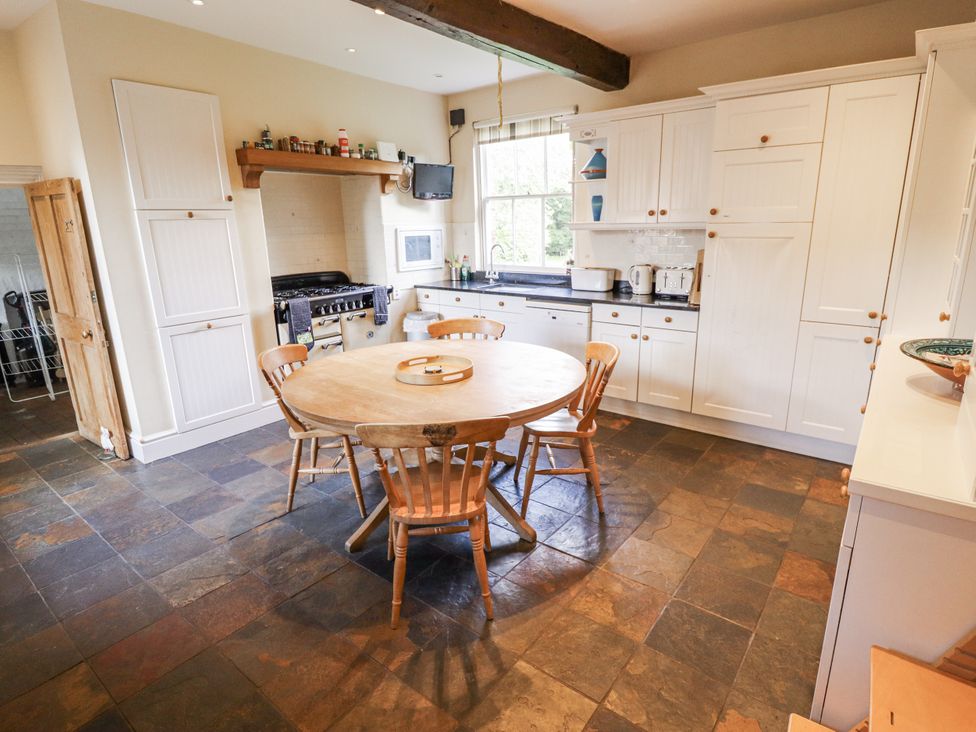 A kitchen with a round table and chairs at Holme Farm in Ruskington