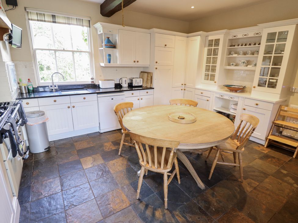 A kitchen with a round wooden dining table and chairs at Holme Farm in Ruskington
