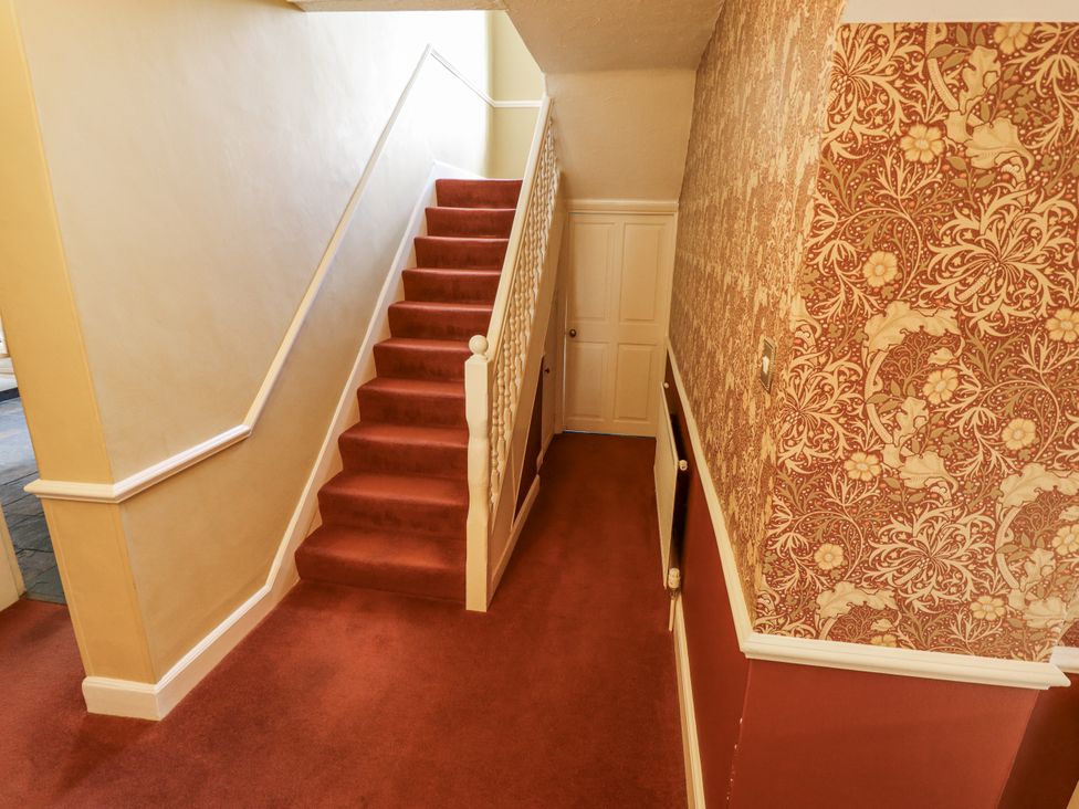 A hallway with a staircase and door at Holme Farm in Ruskington