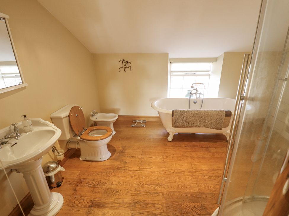 A bathroom with sink, toilet, and bathtub at Holme Farm in Ruskington