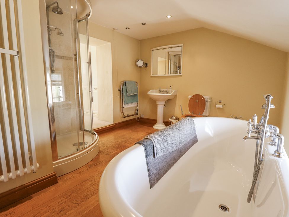A bathroom with a bathtub and shower at Holme Farm in Ruskington